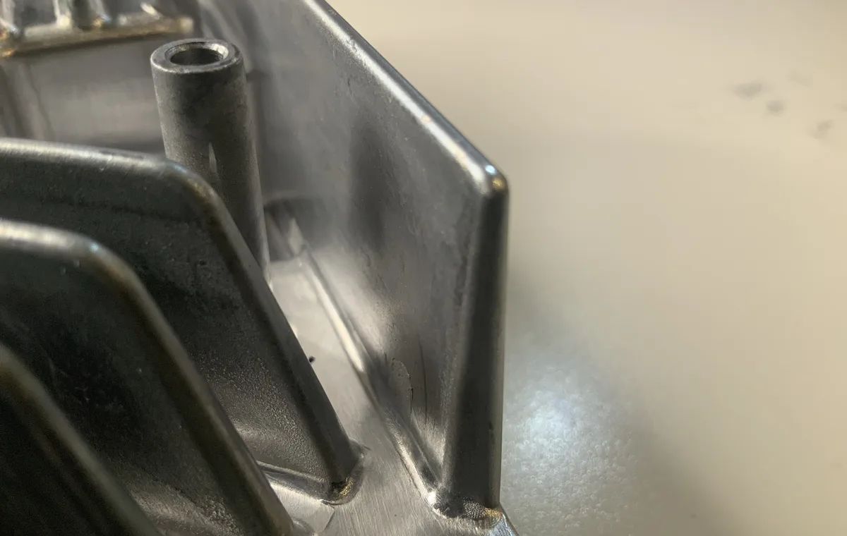 Corner of an aluminium high-pressure die casting showing ribs, a boss and the side wall with its draft angle
